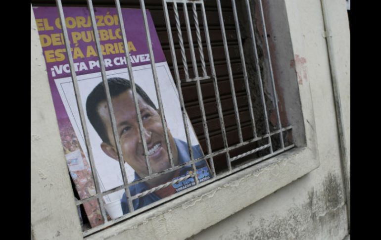 Un póster con la imagen de Chávez es colocado en una ventana en Venezuela. EFE /