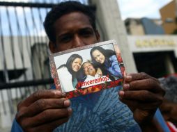 Un hombre sostiene una fotografía de Chávez dada a conocer por el gobierno de Venezuela. AFP /