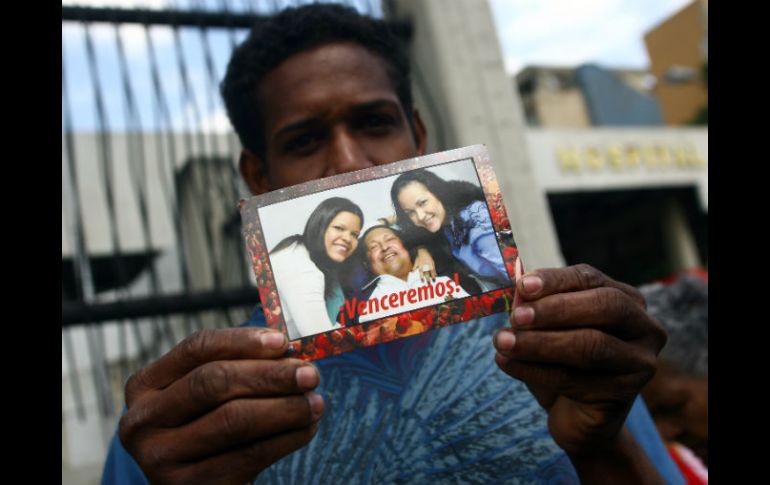 Un hombre sostiene una fotografía de Chávez dada a conocer por el gobierno de Venezuela. AFP /