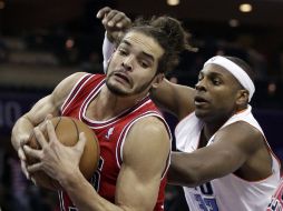 Acción del partido donde Noah de Chicacgo cubre el balón ante Haywodd de Charlotte. AP /