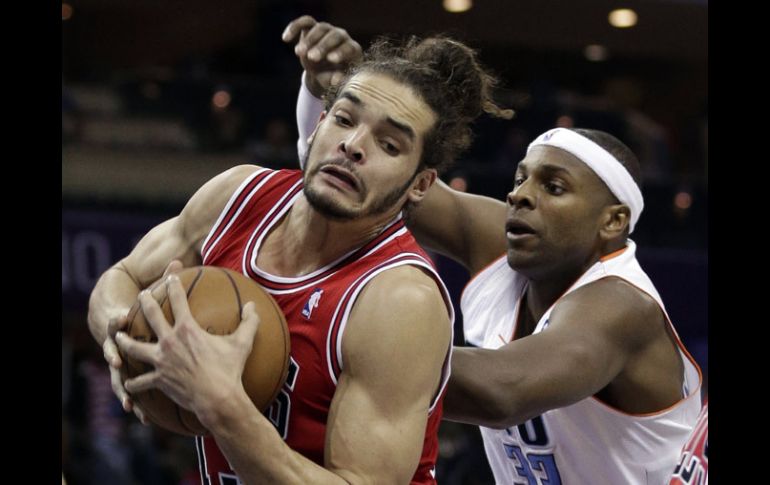 Acción del partido donde Noah de Chicacgo cubre el balón ante Haywodd de Charlotte. AP /