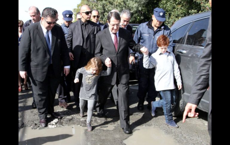 Nicos Anastasiades guía a niños a casillas de votación, durante las elecciones en Chipre. EFE /