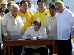 El presidente de Filipinas, Benigno Aquino, firma una ley para indemnizar a las miles de víctimas. AFP /