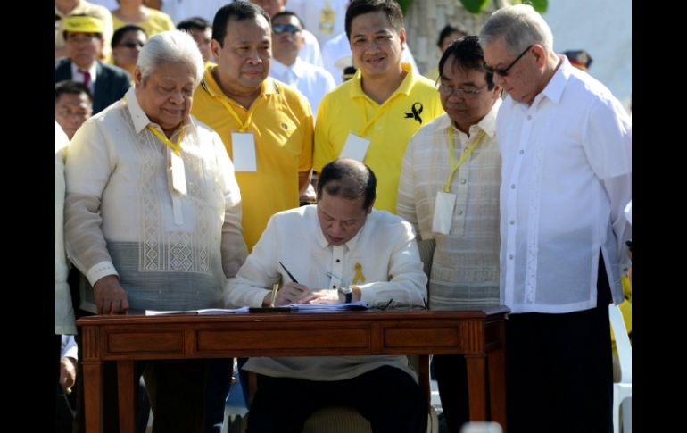 El presidente de Filipinas, Benigno Aquino, firma una ley para indemnizar a las miles de víctimas. AFP /