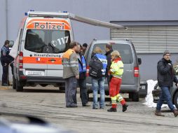 Policías inspeccionan el lugar en el que se ha producido el tiroteo en una empresa maderera de la localidad de Menznau. EFE /