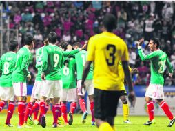 Los mexicanos festejan uno de los cuatro goles que anotaron anoche en el Estadio Cuauhtémoc de Puebla, ante la mirada triste del rival. AFP /