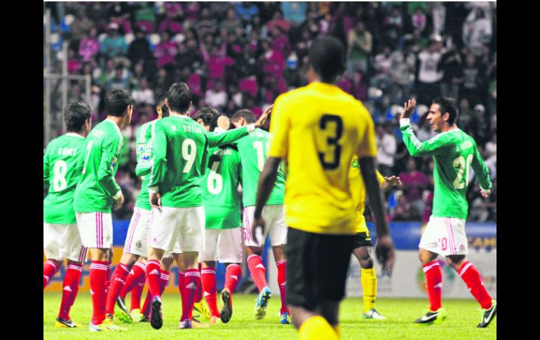 Los mexicanos festejan uno de los cuatro goles que anotaron anoche en el Estadio Cuauhtémoc de Puebla, ante la mirada triste del rival. AFP /