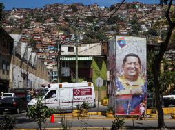 Transeúntes pasan frente a publicidad en apoyo del presidente venezolano, en las afueras del hospital militar. EFE /