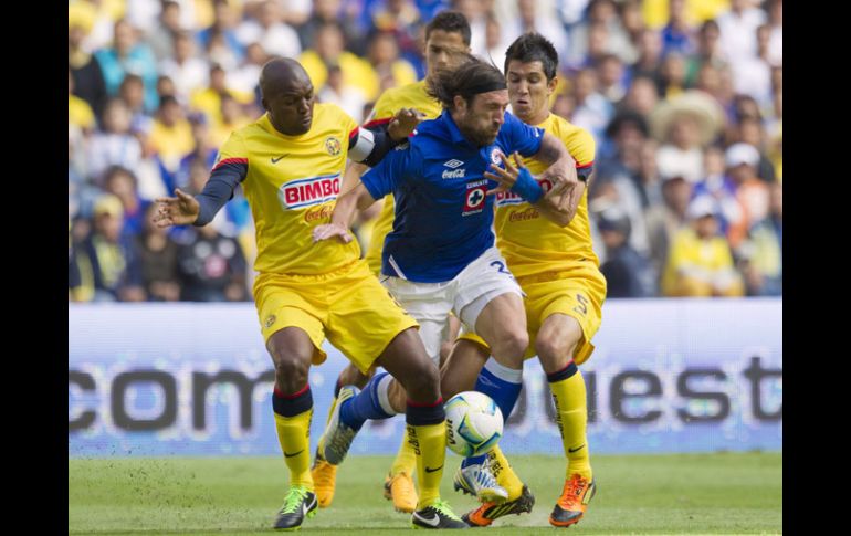 Tres jugadores del América fueron sobre Pavone para quitarle el balón. AFP /