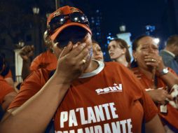 Con playeras rojas y fotografías de Chávez, los venezolanos lloran afuera del Palacio de Miraflores. AFP /