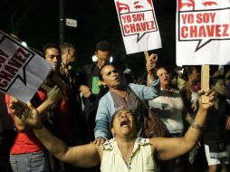 Partidarios de Hugo Chávez lloran su muerte en la Plaza Bolívar; a través de carteles manifiestan el amor por el mandatario venezolano. AP /