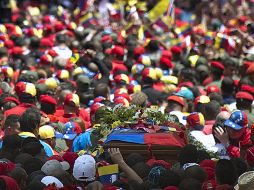 Simpatizantes de Chávez acompañan el féretro del mandatario. AFP /