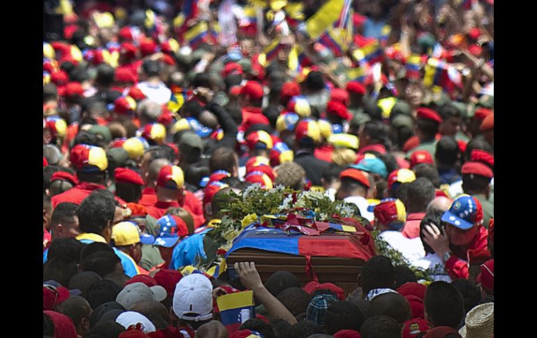 Simpatizantes de Chávez acompañan el féretro del mandatario. AFP /