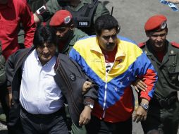 Maduro (c), camina junto a Morales (i) y un oficial de seguridad. AP /