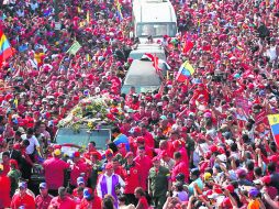 Miles de seguidores acompañan el féretro con los restos del presidente Hugo Chávez, camino a la  Academia Militar. AFP /