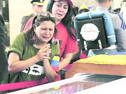 Dos venezolanas lloran frente al féretro del comandante Chávez. Hoy por la mañana será el acto oficial de despedida al presidente. AFP /