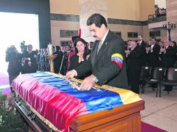 El vicepresidente Nicolás Maduro coloca la espada del libertador Simón Bolívar sobre el féretro de Chávez, en el funeral de Estado. EFE /