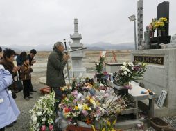 Miembros de una familia en Ishinomaki, oran por los fallecidos en el tsunami, un día antes de el segundo aniversario de la tragedia. EFE /