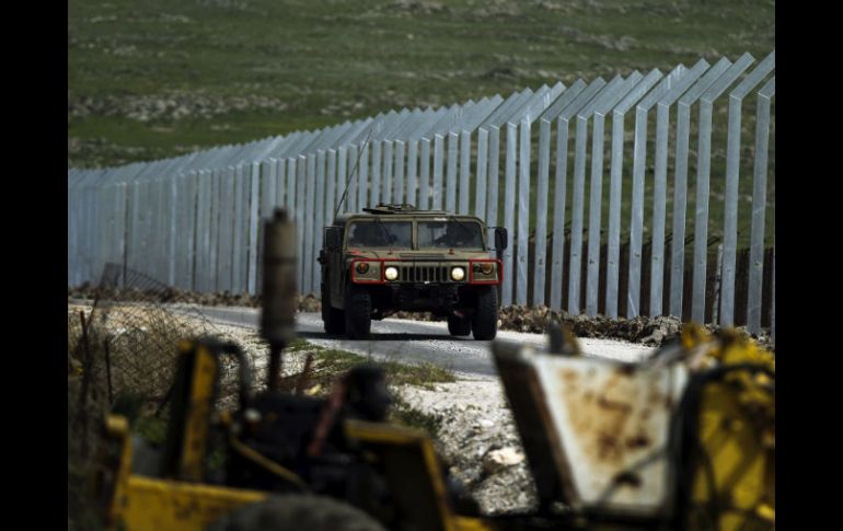 Un vehículo militar israelí patrulla al lado de la nueva valla fronteriza entre Israel y Siria. EFE /