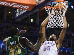 Brandon Bass de los Celtics (i) intenta bloquear una encestada de Kevin Durant, de los Thunder. EFE /