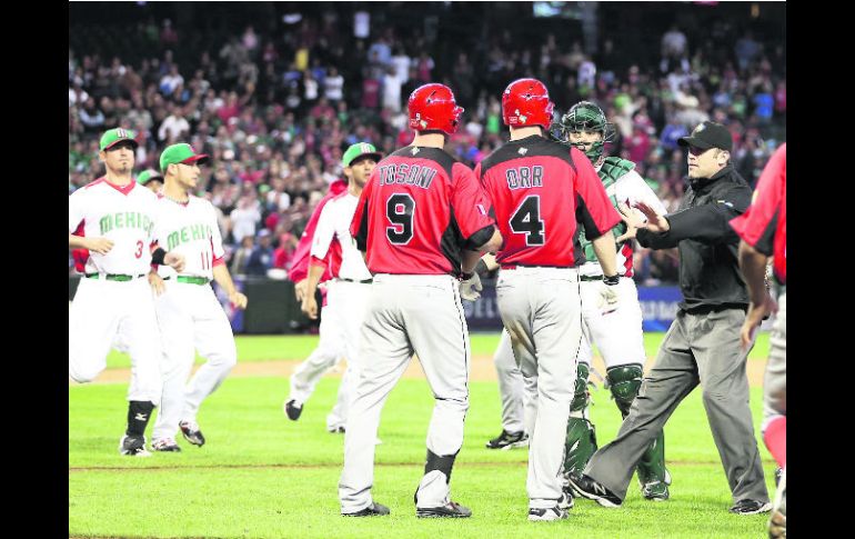 Enfrentamiento. El umpire Brian Knight separa a Pete Orr y Rene Tosoni del receptor mexicano Sebastián Valle. AFP /