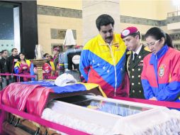 Nicolás Maduro, presidente en funciones, (izquierda) y su pareja Cilia de Flores (derecha), hacen guardia en el féretro de Hugo Chávez. AFP /