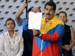 El abanderado presidencial del PSUV muestra el documento de su candidatura. AFP /