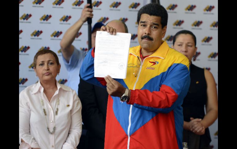 El abanderado presidencial del PSUV muestra el documento de su candidatura. AFP /