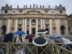 Los fieles y la prensa esperan bajo la lluvia a que se produzca la primera ''fumata''. EFE /