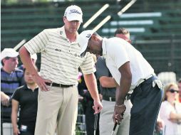 Tiger Woods recibe indicaciones de Steve Stricker mientras practica el putt. AP /