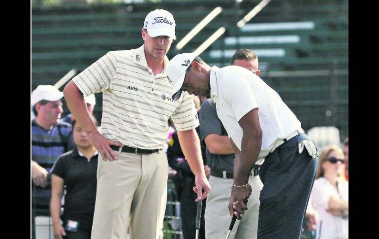 Tiger Woods recibe indicaciones de Steve Stricker mientras practica el putt. AP /