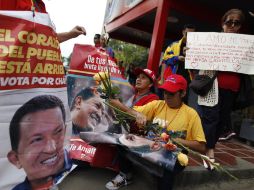 Cientos de venezolanos se concentran para ver el traslado de Hugo Chávez. EFE /