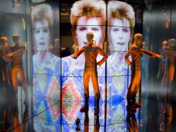 Aderezada con música de Bowie, la exposición envuelve al espectador en los ciclos creativos del más claro referente del glam. AFP /