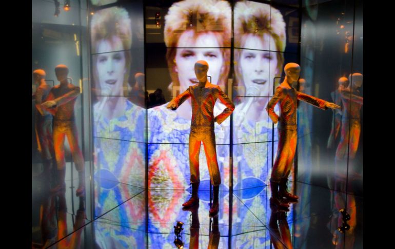 Aderezada con música de Bowie, la exposición envuelve al espectador en los ciclos creativos del más claro referente del glam. AFP /