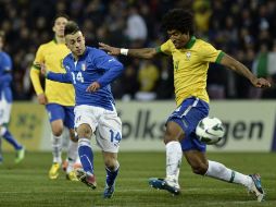 El Shaarawy (izq) saca un disparo ante la marca de Dante de Brasil durante el partido. AP /