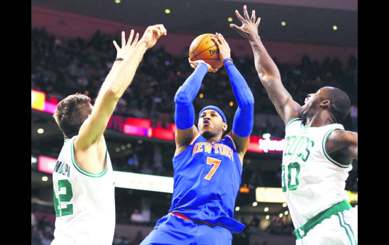 Acertado. Carmelo Anthony (centro) dispara ante la marca de Shavlik Randolph (izq.) y  Brandon Bass. AFP /