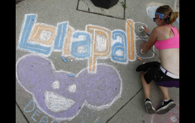 Una mujer realiza un graffiti sobre el festival. ARCHIVO /