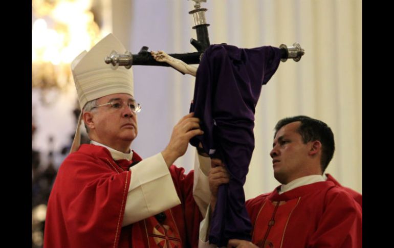 El cardenal Francisco Robles cubre con una tela morada la imagen de Cristo crucificado.  /