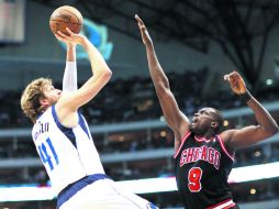 El de la victoria. Dirk Nowitzki dispara ante la marca de Loul Deng para anotar el triple del triunfo. AP /