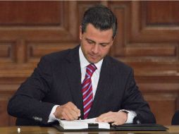 Enrique Peña Nieto mientras suscribe la nueva Ley de Amparo, cuyo objetivo es hacer más accesible y expedito este instrumento jurídico. NTX /