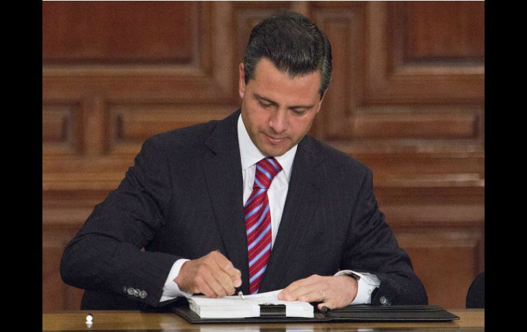 Enrique Peña Nieto mientras suscribe la nueva Ley de Amparo, cuyo objetivo es hacer más accesible y expedito este instrumento jurídico. NTX /