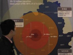 Un hombre mira un gráfico que muestra el daño que recibirían las distintas zonas de Seúl si una bomba de 1 megatón estallara en ella. AP /