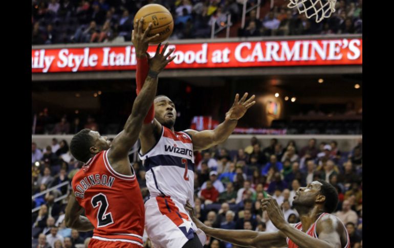 John Wall defendiendo el balón durante el juego. AP /