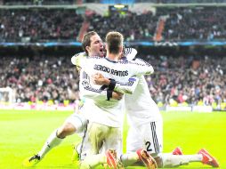 Sentencia. El argentino 'Pipita' Higuaín es felicitado por Sergio Ramos (4) y Varane (2),tras anotar el tercer y último gol del partido AP /