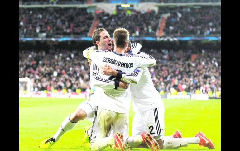 Sentencia. El argentino 'Pipita' Higuaín es felicitado por Sergio Ramos (4) y Varane (2),tras anotar el tercer y último gol del partido AP /