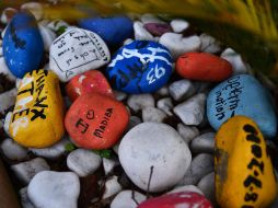 Piedras pintadas con mensajes de buenos deseos para Mandela permanecen fuera del hospital dónde se encuentra. AFP /