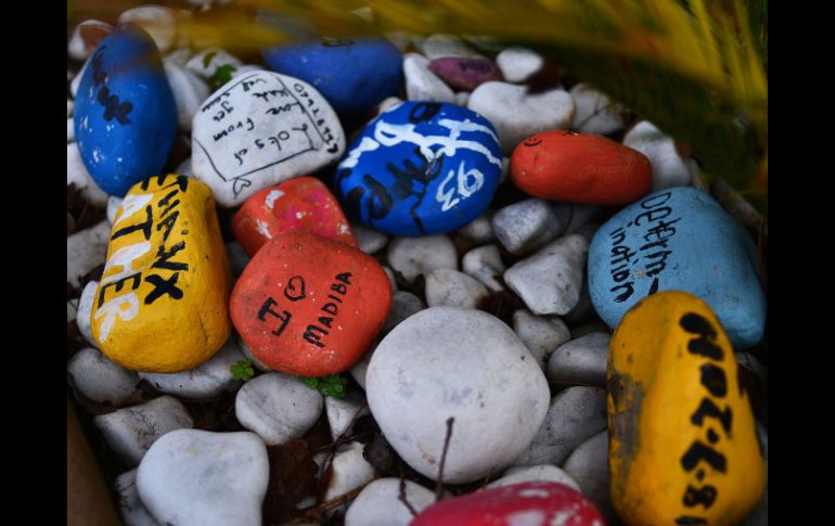 Piedras pintadas con mensajes de buenos deseos para Mandela permanecen fuera del hospital dónde se encuentra. AFP /