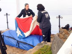 El ataúd con los restos mortales del poeta es envuelto en la bandera chilena antes de su traslado a Santiago. AFP /