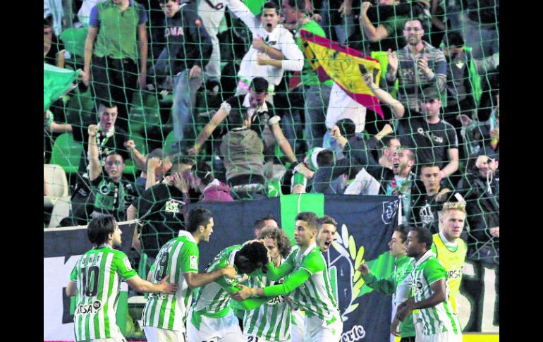 Explota el ''Villamarín''.  Jugadores y afición del Betis festejan el gol que le dio el empate ante el Sevilla. AFP /