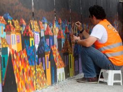 Un ayudante termina un mural en Quito, como parte de esta interesante propuesta artística. EFE /